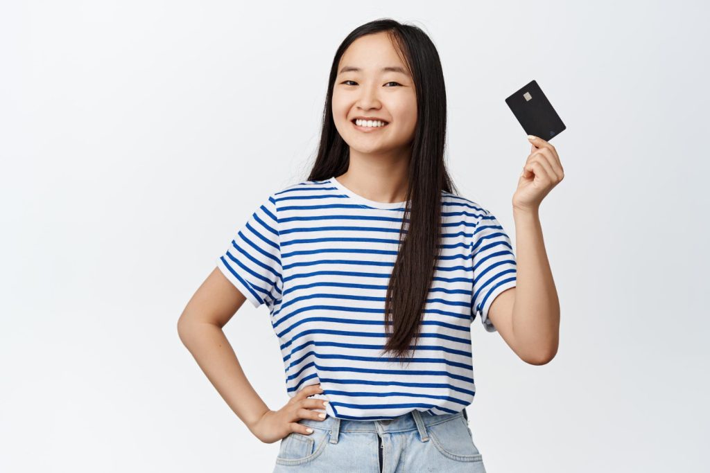 A happy girl holding her Amazon Prime Visa Card.