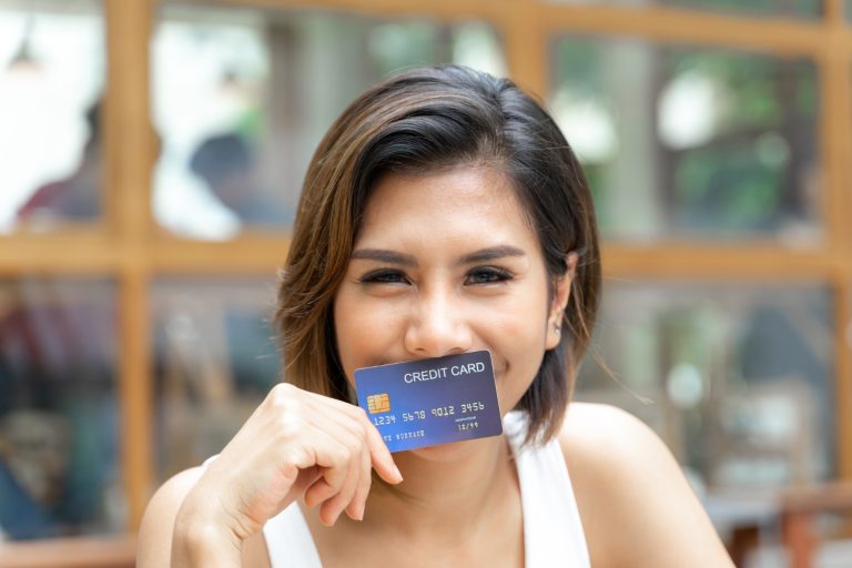 Woman holding her Bank of America Travel Rewards card.