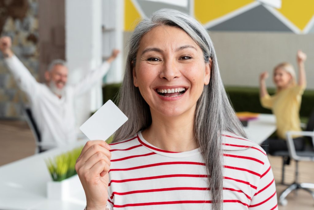 A happy woman holding her CareCredit Card.