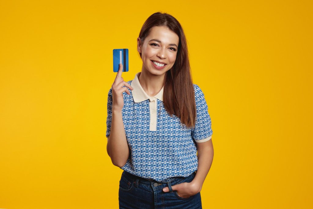 Woman being happy and holding her Discover it Balance Transfer.