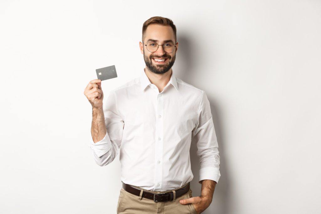 A man holding his QuicksilverOne Capital One.